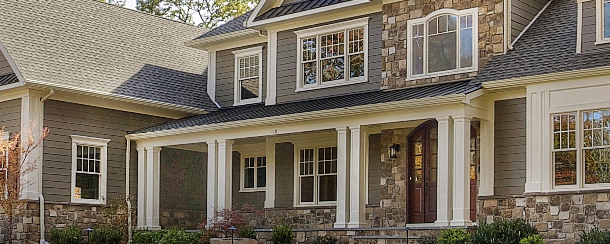 Stone and siding craftsman home with a covered front porch