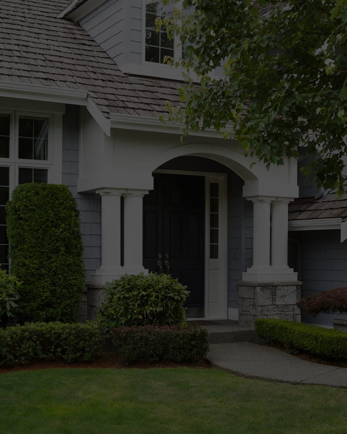 Residential home exterior with a landscaped front entry