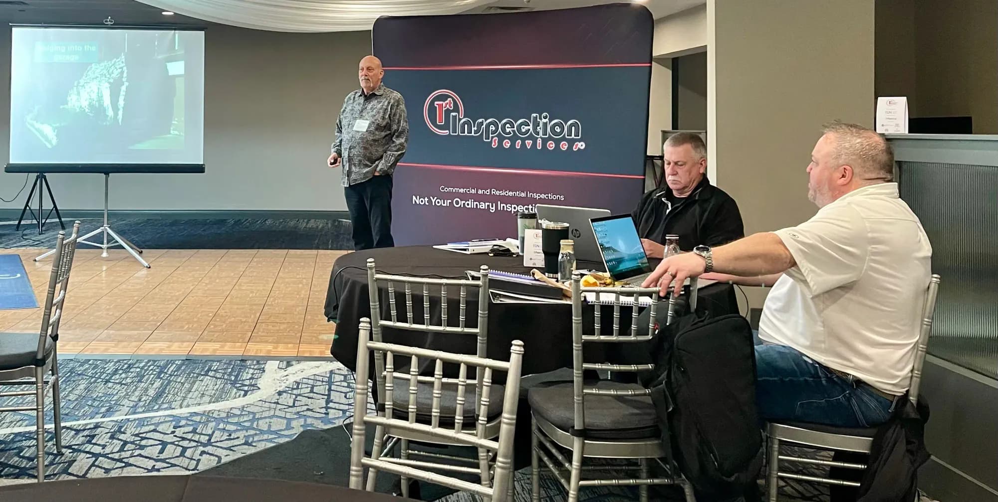 Presenter leading a 1st Inspection Services training session while inspectors take notes